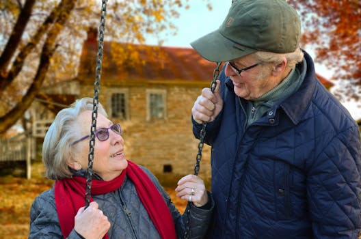 Huyết áp cao: Thời điểm nào cần bắt đầu dùng thuốc? A happy elderly couple sharing a joyful moment on a swing in autumn setting.